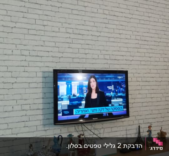 קיר לבנים לבן עם טלוויזיה תלויה